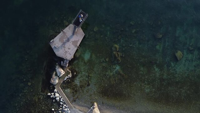 Top down aerial view of a large diving board along the Lake Geneva waterfront near Lutry, Switzerland.
