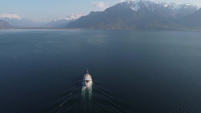 Aerial subject tilt up shot of a ferry boat on Lake Geneva near Lausanne, Switzerland on a sunny day.