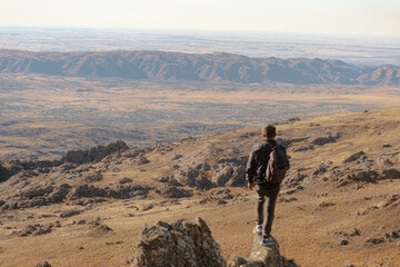 man standing on a slope with a large background