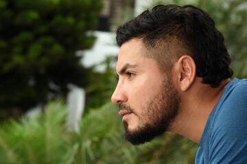 man looking out a window from home, pensive