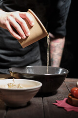 Chef pouring broth, cooking asian dish