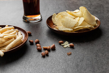 Potato chips, French fries snackม peanut and a glass of cola. Food and drink concept.