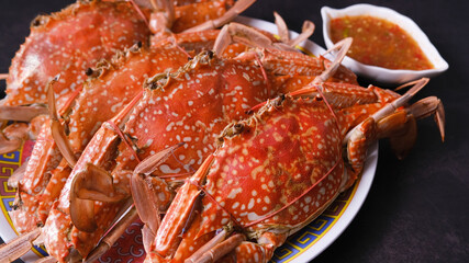 Steamed crabs with spicy sauce isolated on black background. 