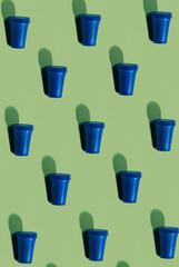 Cup serving pattern. Tableware background. Picnic utensils. Plastic reclamation. Set of blue abstract disposable empty glasses isolated on olive green surface.