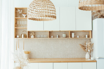 Wooden cutlery and dried flowers and spikelets in a bottle on the kitchen table and shelves. Scandinavian style. Eco friendly kitchen utensils and decoration. Layout, mockup for design
