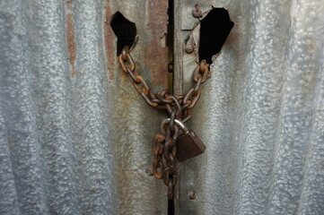 old rusty lock and door with chains outside