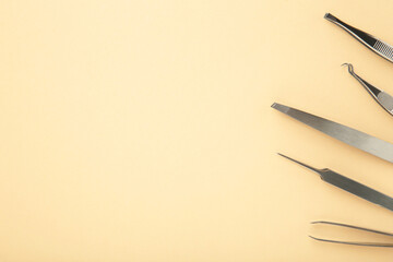 Beauty and fashion concept - tools for Eyelash Extension Procedure. Tweezers on beige background. Copyspace mockup