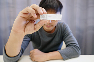 Man shows results of coronavirus test with covid-19 self-test (rapid antigen test).
