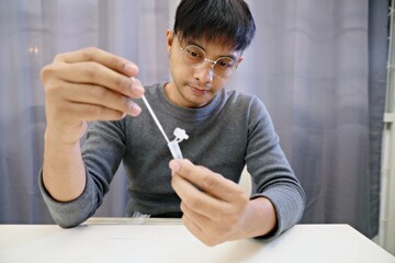 Man uses cotton swab to test for Covid-19 Insert a reagent bottle to look for what is believed to be a virus.