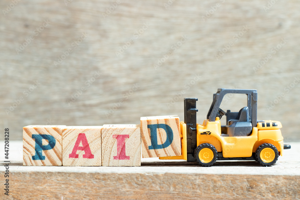 Canvas Prints Toy forklift hold letter block d to complete word paid on wood background