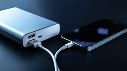 Phone power bank. Mobile phone or smartphone battery charging from portable powerbank with white...