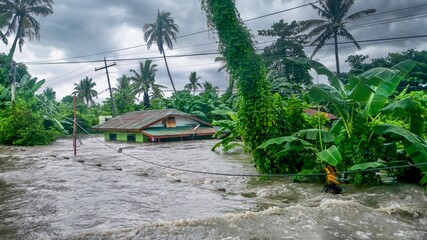 Rising water levels submerging a house as heavy monsoon rains cause major floods in Baco, Oriental Mindoro, Philippines on July 23, 2021. - obrazy, fototapety, plakaty