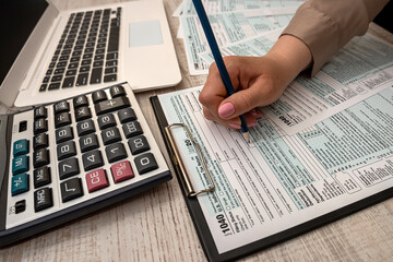 woman fills in individual tax form 1040