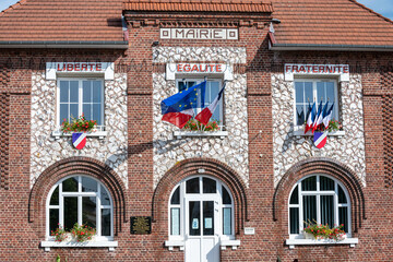 Obraz premium Facade d'une mairie avec drapeaux français bleu blanc rouge et européen, à l'occasion de la fête nationale du 14 juillet. Devise sur la facade : Liberté, Egalité, Fraternité