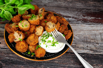 Whole breaded button mushrooms with soured cream and chive dip