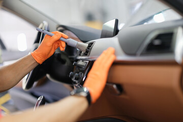 Male hand hold grey blush in orange protective gloves