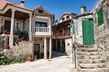 Hermosa callejuela de edificios bajos y arquitectura de piedra en la villa de Combarro, provincia de Pontevedra, España - obrazy, fototapety, plakaty