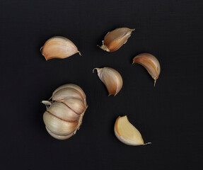 Garlic with segments, peeled cloves, isolated on black background. For menu.
