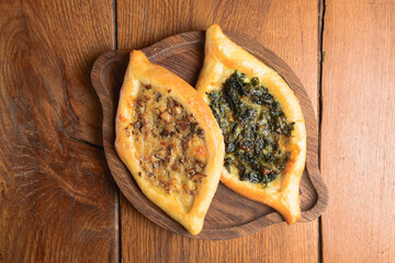 Khachapuri with meat, mushrooms and greenery. Made from beef tenderloin, mushrooms, cream sauce, herbs.