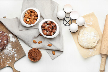 Fresh dough with ingredients for preparing bakery and utensils on light background