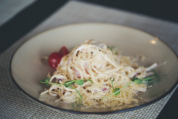 pasta carbonara in a plate is on the table