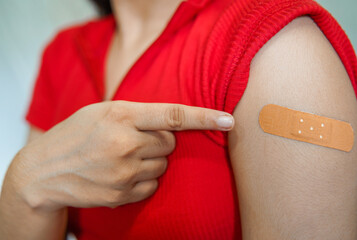Closeup of Indian young girl after getting vaccination during covid-19, bandage applied on her arm after vaccinated, Coronavirus population immunization campaign.