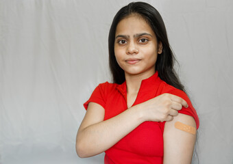 Indian young girl after getting vaccination during covid-19, bandage applied on her arm after...