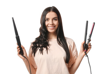 Beautiful young woman with curling and flattening irons on white background