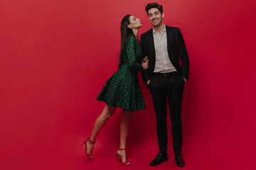 Attractive young couple of handsome man in black suit and white shirt smiling, and pretty young...