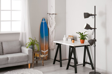 Interior of modern stylish room with table, sofa surfboard