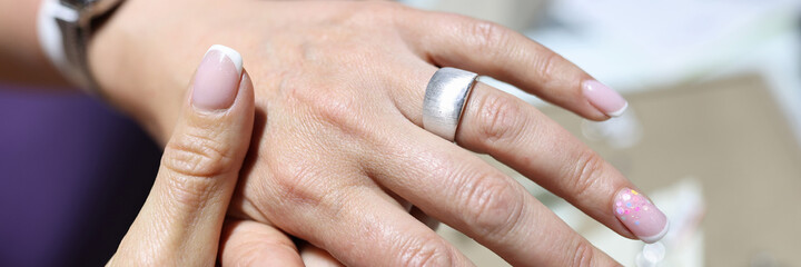 Woman tries on wide silver ring on her finger