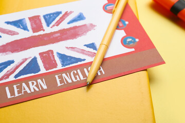 Stationery and paper with text LEARN ENGLISH on color background, closeup