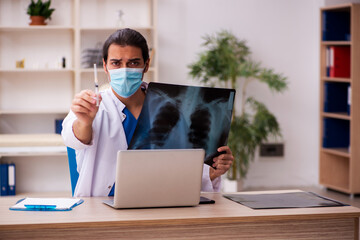 Young male doctor radiologist wearing face-mask during pandemic