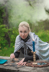 Magical ritual with a candle and spell in forest. Witchcraft and esoteric concept. Wicca or paganism