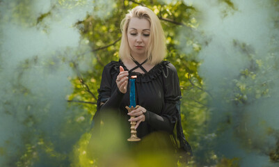 Magical ritual with a candle and spell in forest. Witchcraft and esoteric concept. Wicca or paganism