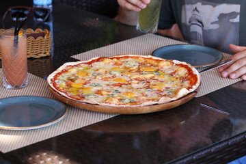 pizza four cheeses on a thin dough is on the table