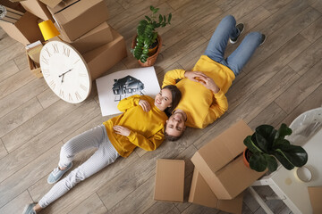 Young couple with belongings in their new house on moving day
