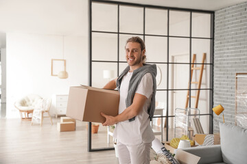 Young man with box in room on moving day