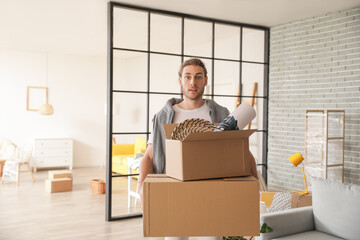 Young man with boxes in room on moving day