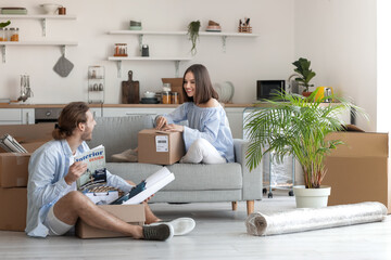 Young couple with cardboard boxes in their new house on moving day