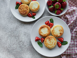 Cottage cheese pancakes, ricotta fritters on ceramic plate with  fresh strawberry.