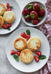 Cottage cheese pancakes, ricotta fritters on ceramic plate with  fresh strawberry.