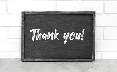 Thank you lettering on the black board. Creative design. Appreciation for the service.