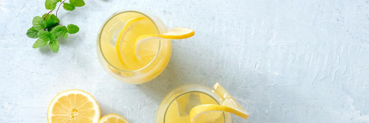 Lemonade panorama. Fresh citrus beverage panoramic banner. A glass of lemon ice tea with mint and...