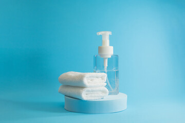 A bottle of hand sanitiser and two white towels to fight against the pandemic. Protect yourself from the covid 19 viruses. 