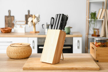 Stand with set of knives on table in kitchen