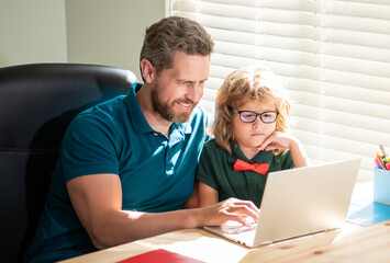 bearded father and son in glasses use computer at home. family blog. nerd boy do homework