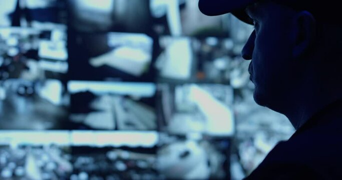 Male Officer Sits in a Control Room in front of a Surveillance CCTV Video in a Harbour Monitoring Center with Multiple Cameras in Profile in Front of Displays with Big Data he Drinks Coffee and Report