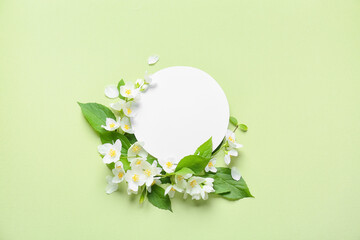 Blank card and beautiful jasmine flowers on color background