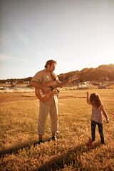 Father with daughter playing music, singing songs and enjoying summertime vibes.